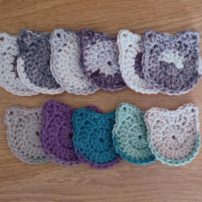Crocheted car coasters shaped like cat heads.